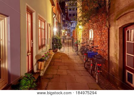 The old narrow medieval street in the historic part of the city in the night illumination. Bremen. Germany.