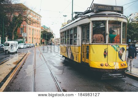 LISBON, PORTUGAL - February 2017:Famous yellow tram 28 line on station in front of Basilica Estrella,public transport that is attractions of Lisbon and Portugal