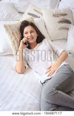 Pretty teenage girl talking on phone about her intimacy secret
