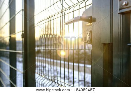 entrance to the playground of fence and the wicket of the welded wire mesh green color with a metal lock and handle
