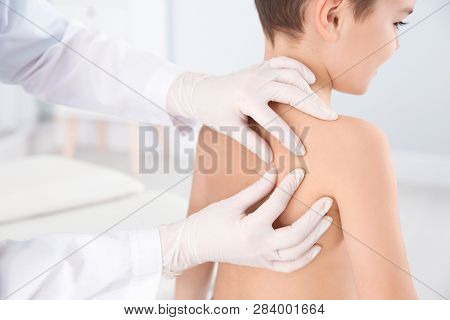 Dermatologist Examining Little Boy's Birthmark In Clinic