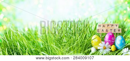 Phrase Happy Easter Made Of Letters On A Background Of Green Grass, Easter Eggs.