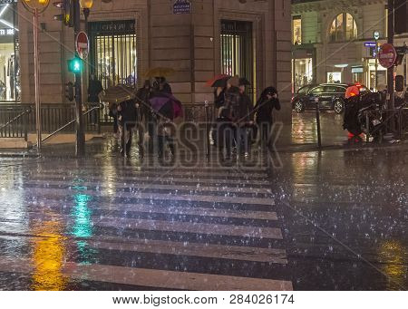 Paris, France - December 10, 2017: People Cross The Street In The Pouring Rain. Paris, Boulevard Hau