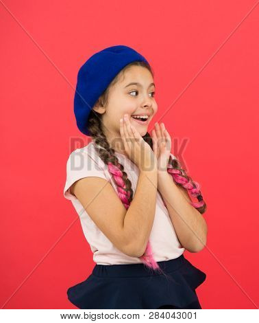 Amazed Girl. Kid Little Cute Fashion Girl Posing With Long Braids And Hat Red Background. Child Smal