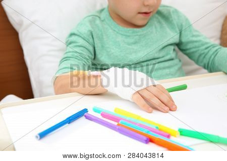 Little Child With Infusion Drip Drawing In Hospital Bed, Closeup