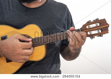 Young Man Playing Ukulele With Shirt And Black Pants.