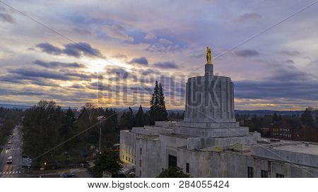 The State Capital Building Adorned With The Oregon Pioneer With Downtown Salem In The Background