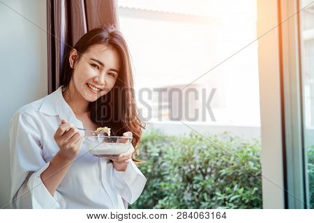 Asian Girl Who Just Wake Up In The Morning As Relaxed. She Opened The Window To Receive The Light Of
