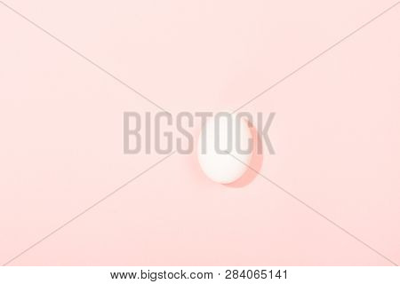 White Egg On Pink Background. Minimal Foood Concept. Flat Lay, Top View. Copy Space For Your Text.