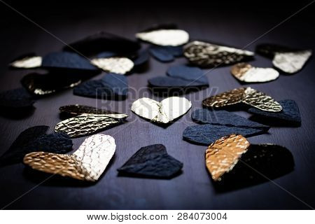 Group Of Black And Golden Foil Hearts On The Wooden Table