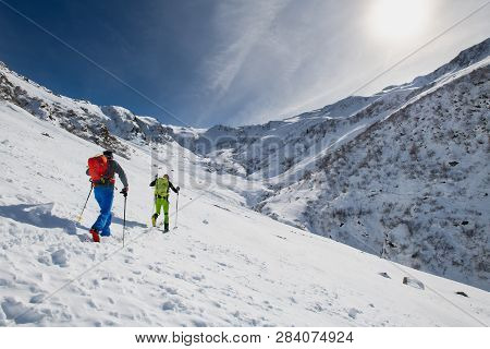 Couple Of Friends Uphill With Skis And Seal Skins.