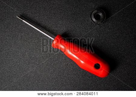 Red Screwdriver With The Detail On The Black Background