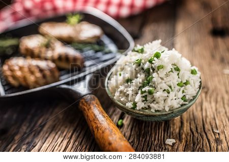 Rice Basmati With Green Peas In Bowl And Grilled Chicken Breast In The Background