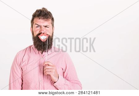 Emotional Dissonance Concept. Man Holding Party Props Smiling Lips While His Face Serious, White Bac