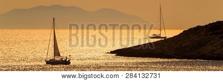Panoramic web banner silhouettes of yacts or boats sailing at sunset, Hvar, Croatia, Europe