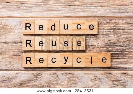 Reduce, Reuse And Recycle Word Written On Wood Block. Reduce, Reuse And Recycle Text On Wooden Table