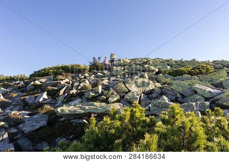 Mountain Rocky Terrain. Woman With A Child On A Journey.