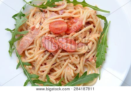 Spaghetti With Schurwald Ham, Sauce And Fresh Argula, Tomatos. Pasta On White Plate.