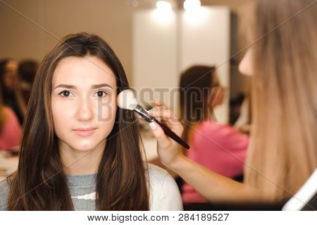 Make Up Artist Doing Professional Make Up Of Young Woman.