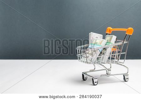Supermarket Cart With Packs Of Dollars. The Concept Of Microcredit And Payday Loans. Advertising Fin