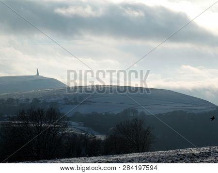 Snow Covered West Yorkshire Pennine Landscape With Stoodley Pike Monument In The Distance And A Crow
