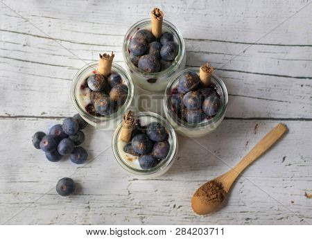 Homemade Yogurt With Blueberries On A White Wooden Table. View From Above