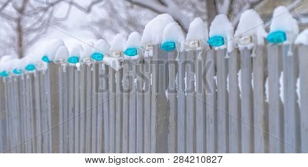 Snowy Fence Lined With Light Bulbs In Daybreak