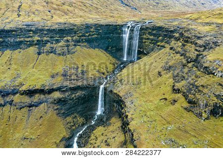 Aerial view of Fossa Waterfall, the highest waterfall in the Faroe  Islands. This double-tiered waterfall is 459 feet high and cascades down into the sea.