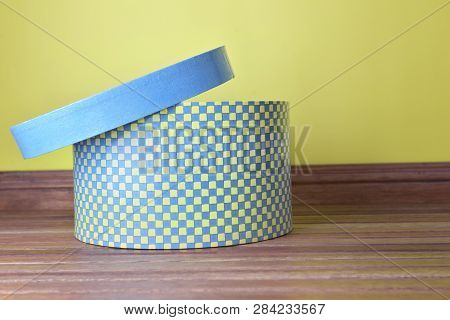 Decorative Hatbox With Open Lid On Wooden Floor