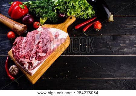 Raw Pork Meat. Fresh Steaks Tenderloin On Wooden Cutting Board On Dark Background And Copy Space For