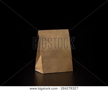Blank Craft Paper Bag On Wooden Background. Responsive Design Mockup.