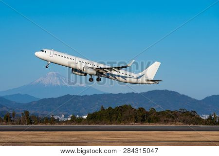 Airplane Taking Off Scene With Mount Fuji Background In Winter.