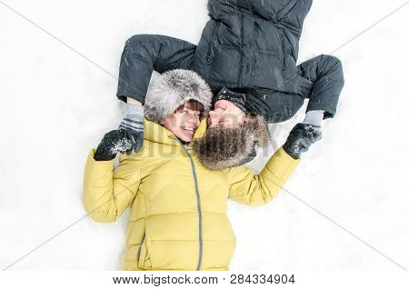 Russia, Ryazan 04 Jan 2017: Husband Lying On The Snow And Hugs Pregnant Wife In Winter Frozen Forest