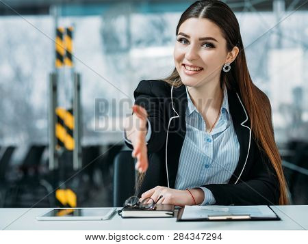 Friendly Hr Portrait. Smiling Intern Woman Standing At Counter Extend Welcoming Hand. Office Workspa