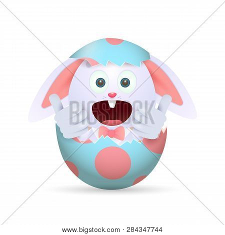 Happy Bunny Sitting In Easter Egg. Joyful Little Rabbit Hiding In Cracked Egg And Showing Thumbs-up.
