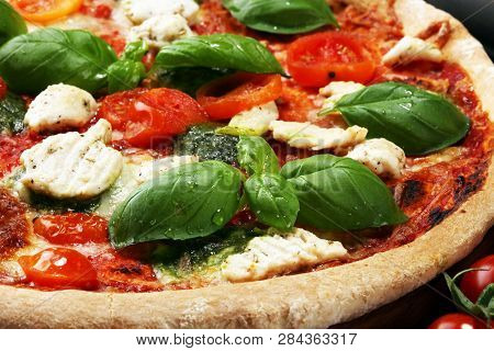 Pizza With Tomatoes, Mozzarella Cheese, Black Olives And Basil. Delicious Italian Pizza On Wooden Pi