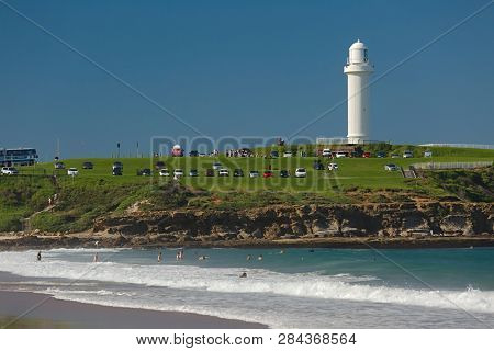 WOLLONGONG, AUSTRALIA - MARCH 25, 2016: People enjoying swimming in the ocean nearby Wollongong Lighthouse, Flagstaff Hill Park