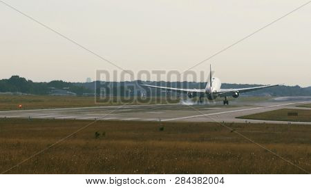 Widebody Twin Engine Commercial Airplane Landing In The Airport At The Sunrise.