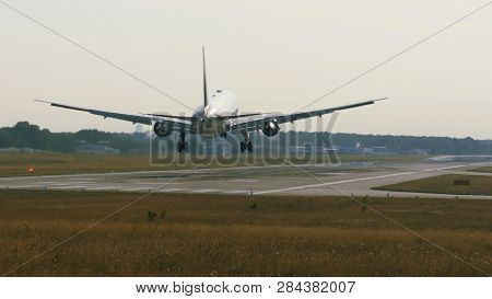 Rear View Of Widebody Twin Engine Airplane Arrive To Airport At The Sunrise.