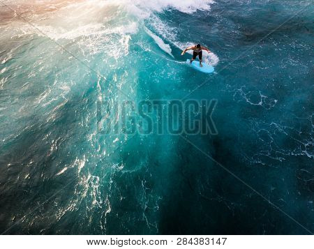 OAHU / USA - 15 NOVEMBER 2018: Surfer rides the ocean tropical wave. Aerial view of Makaha surf spot, west coast of Oahu, Hawaii