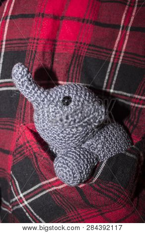 Little Grey Elephant Crocheted Sitting In A Pocket Shirt With Red, Black And White Cage