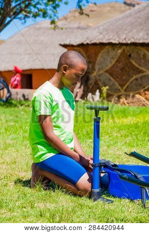 African Children Fixing A Puncture On A Bike