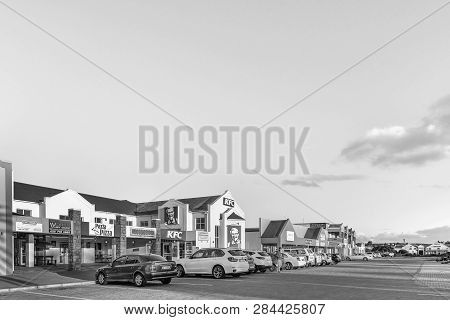 Langebaan, South Africa, August 20, 2018: A Sunset Street Scene, With Businesses And Vehicles, In La