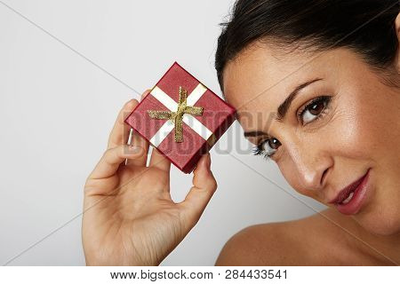 Fashion Photo Of A Beautiful Brunette Woman With Dark Short Hair Holding Hand Gift Box Over White Em