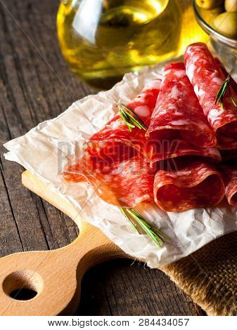 Italian Salami With Olives And Spices On Wooden Background