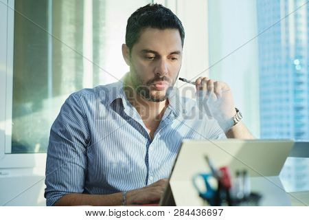 Ex-smoker Man Smoking Electronic Cigarette In Office While Working
