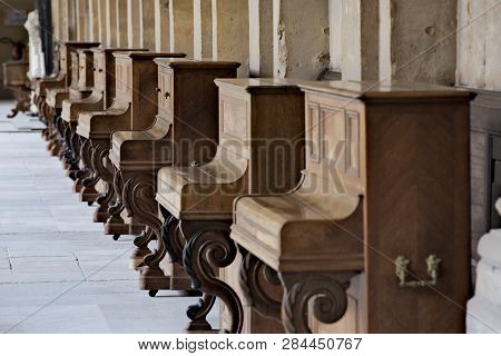 Peculiar Vintage Pianos Collection Aligned In Bright Monastery Cloisters, Offering Nice Contrast Bet