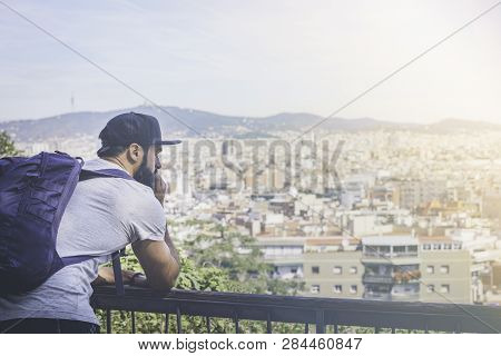 Traveler Man Looking On A Big City, Travel And Active Lifestyle Concept.bearded Tourist Man With Bac