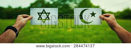 Religion Conflicts As Global Issue Concept. Two Hands Holding Different Faith Symbols, Judaism Vs Is