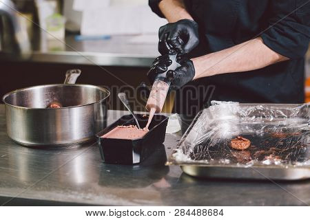 Theme Cooking. Hands Close Up. Young Caucasian Man In Black Uniform And Latex Gloves In Kitchen. Res
